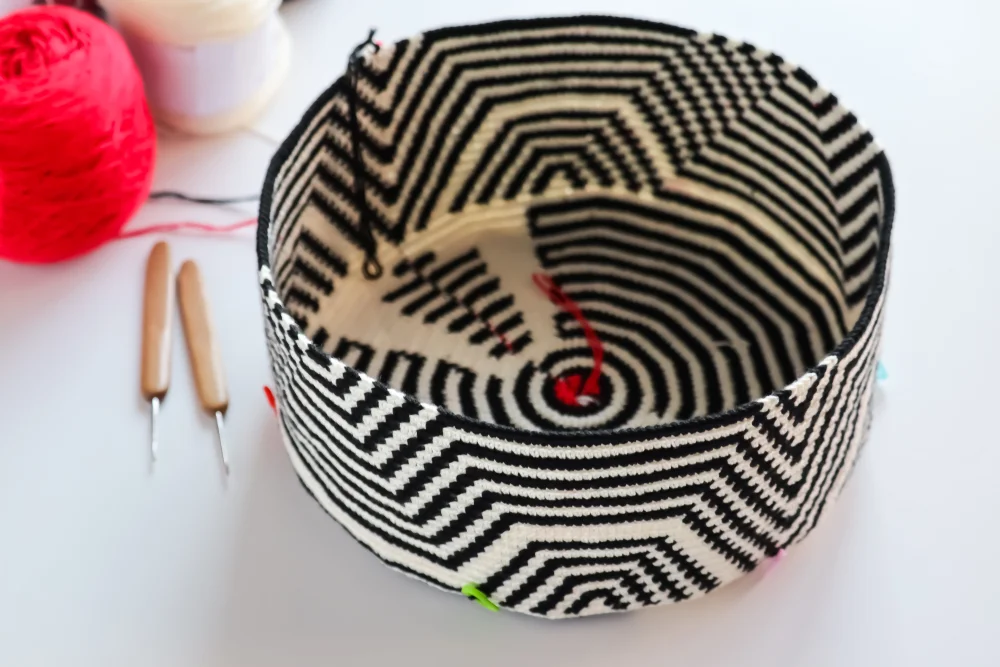Mochila,Wayuu,Crochet,Bag,With,Yarn,Ball,And,Wood,Crochet Black and white Wayuu bag under construction