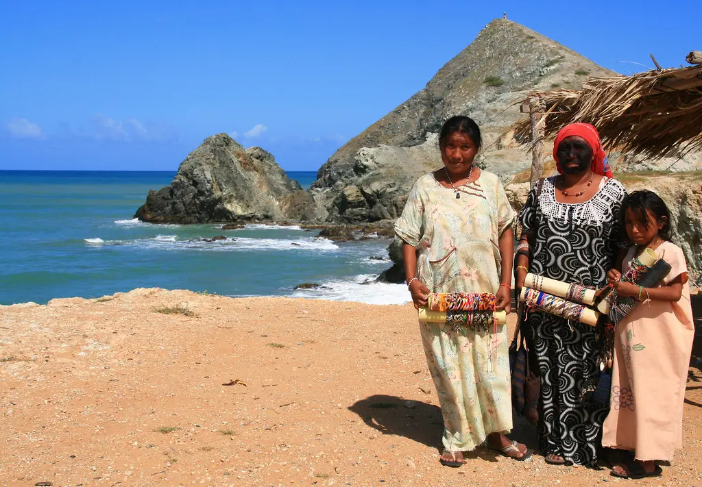 Wayuu-family-standing-on-the-sand-with-the-sea-in-the-background